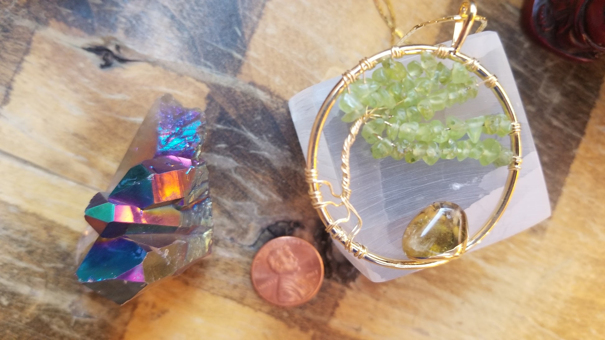 peridot tree of life necklace in gold with amethyst atop selenite charging stone